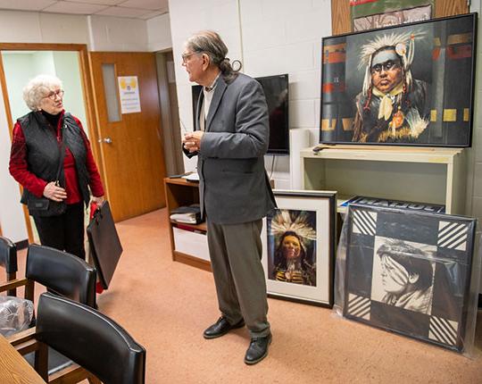 photo of woman and man looking at paintings